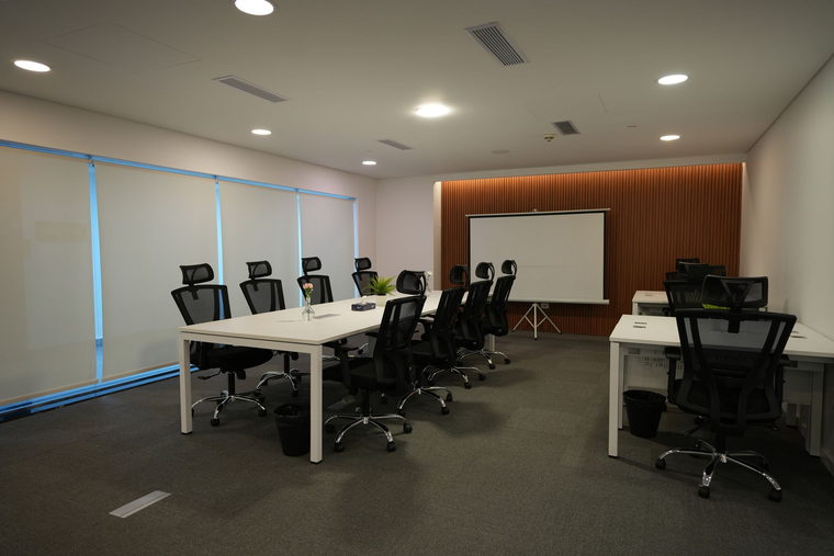 Imagem de referência: sala de reunião de coworking com mesa longa e cadeiras