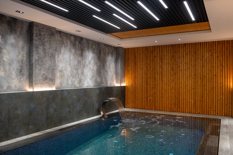 Imagem de referência: piscina coberta com iluminação baixa e revestimento em madeira