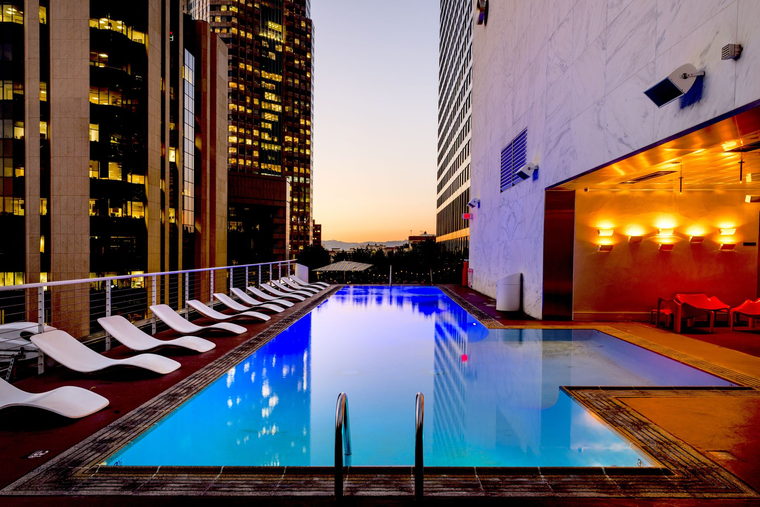 Imagem de referência: piscina descoberta em rooftop de edifício ao anoitecer